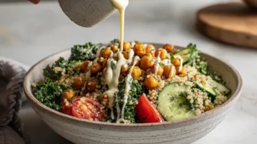 high protein chickpea bowl with tahini drizzle, kale, quinoa and vegetables