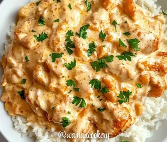 Delicious creamy smothered chicken served over rice