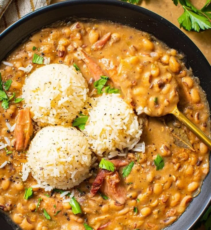Bowl of creamy Southern black-eyed peas garnished with herbs.