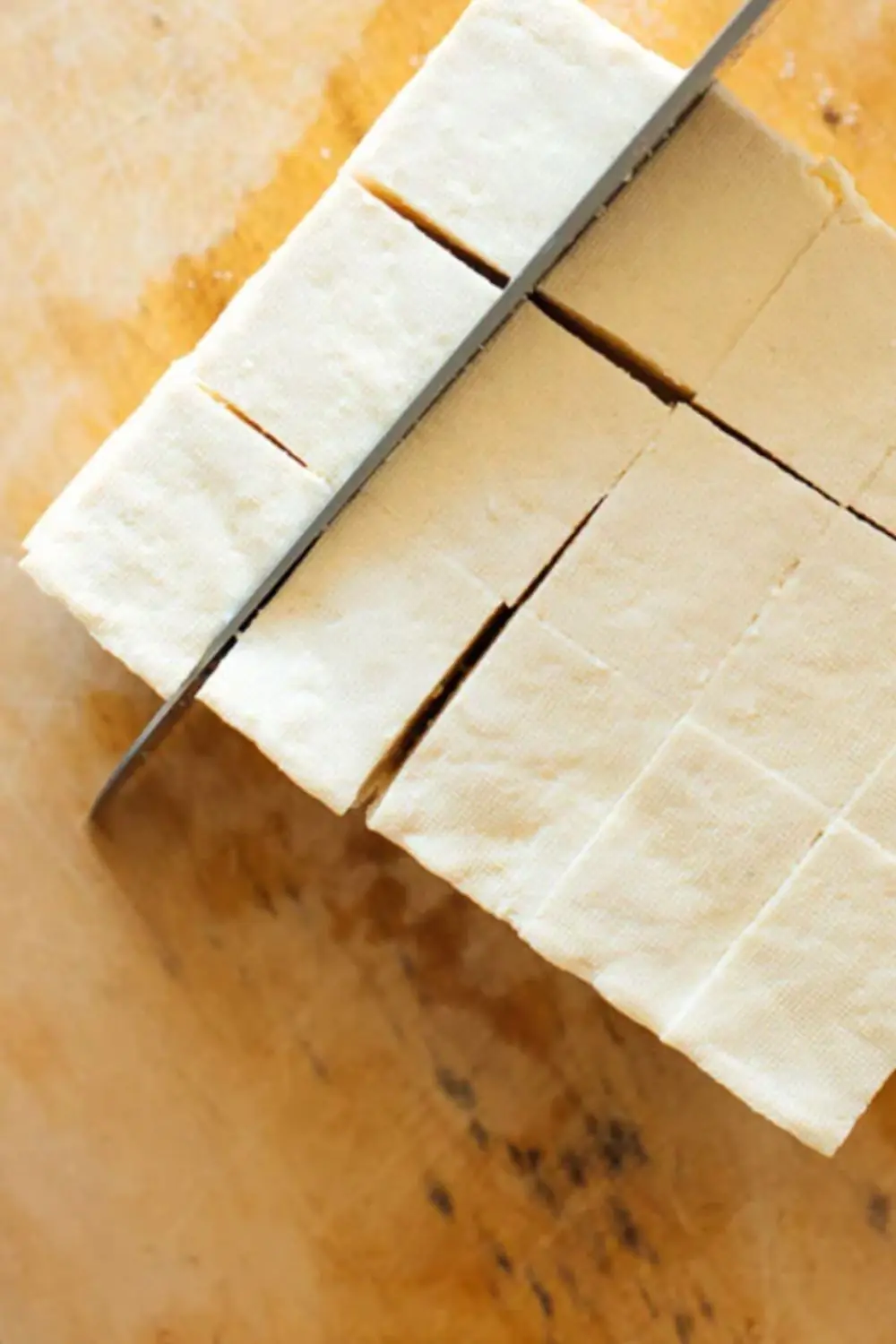 Cubed tofu on cutting board ready for seasoning