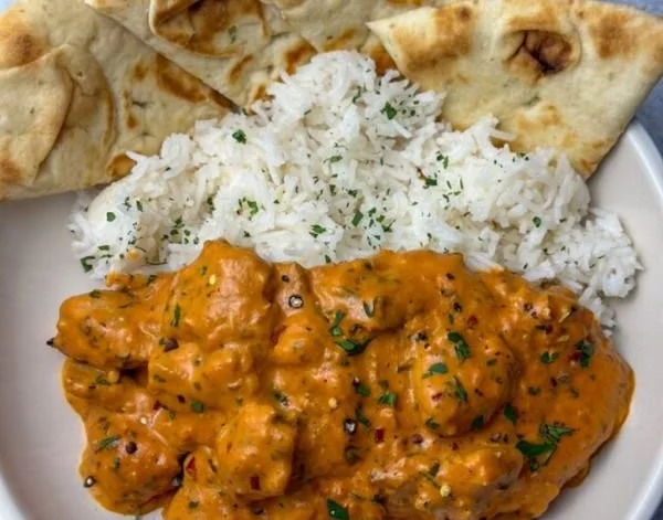 Delicious homemade butter chicken served with rice and naan