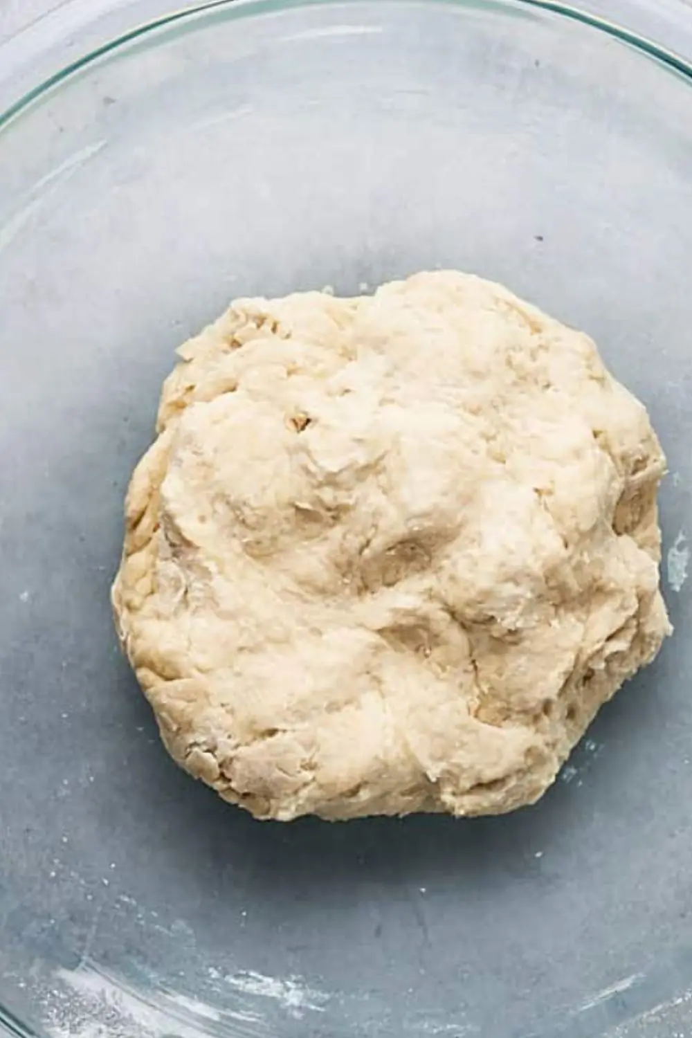 coarse vegan pizza dough in glass bowl during mixing stage