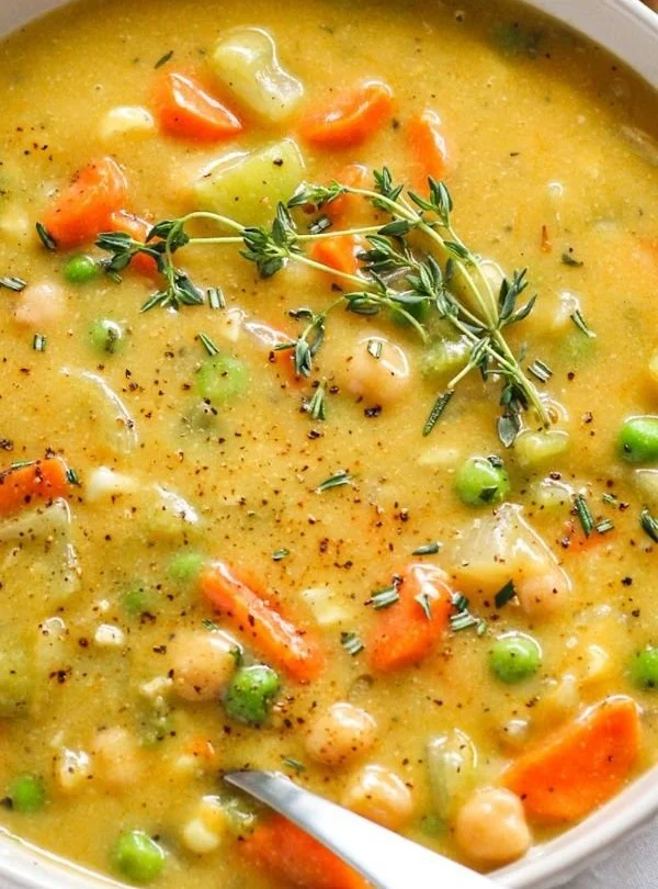 Bowl of comforting one-pot creamy vegetable soup with fresh vegetables