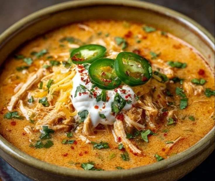 Bowl of creamy chicken enchilada soup garnished with cilantro and cheese