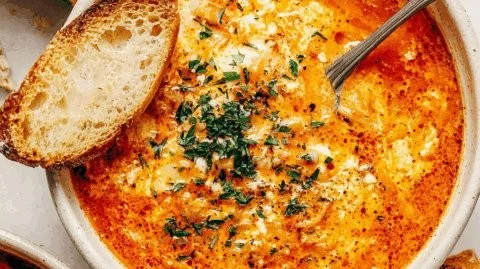 Bowl of creamy garlic soup garnished with fresh herbs