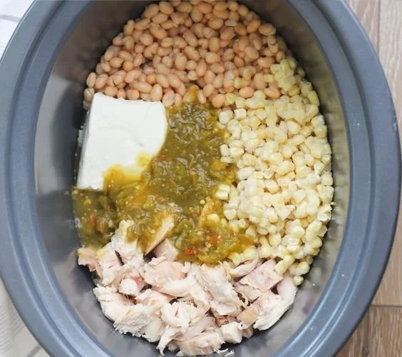 Bowl of Green Chile Chicken Enchilada Soup garnished with cilantro and lime.