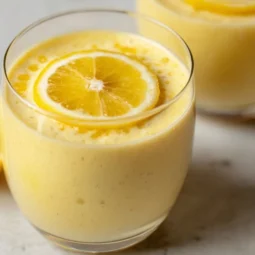Bowl of Lemon Cream Chia Pudding topped with fresh lemons and mint leaves