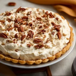 Delicious pecan cream pie topped with whipped cream and pecans