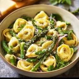 A vibrant Spring Tortellini Salad with fresh vegetables and herbs.