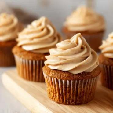 Delicious carrot cake cupcakes with cream cheese frosting on a decorative plate