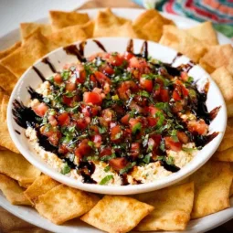 Delicious bruschetta dip served with fresh bread and vibrant toppings.