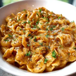 Bowl of Easy French Onion Pasta topped with melted cheese and caramelized onions.