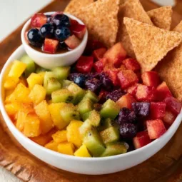 Bowl of vibrant fruit salsa served with crispy cinnamon chips